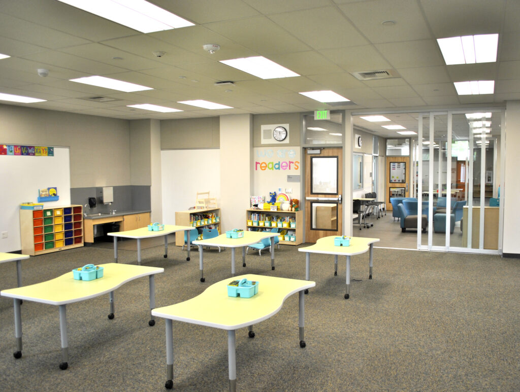 Bright and open classroom space at Mabel Mattos Elementary School with colorful tables and breakout areas.