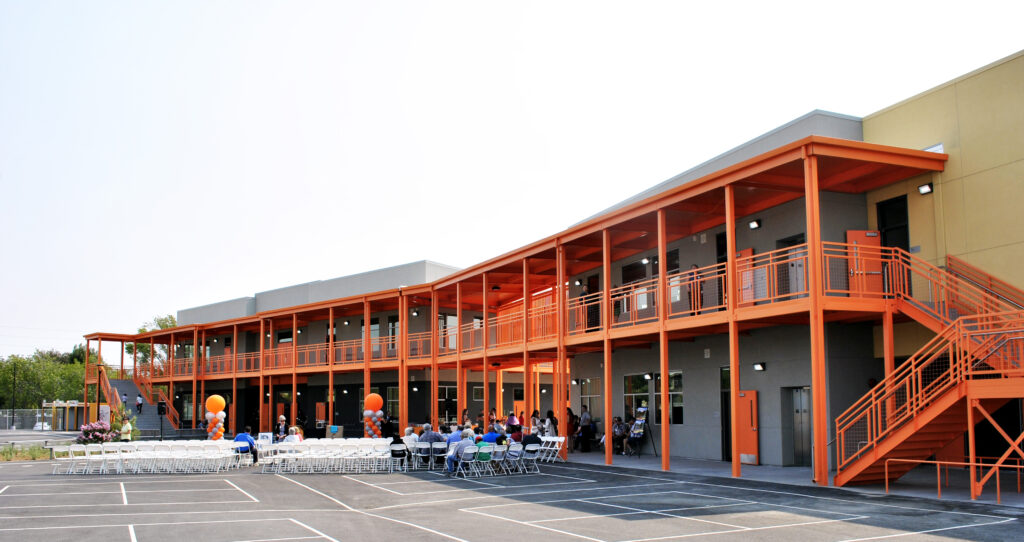 Rear view of the two-story modular classroom building at Mabel Mattos Elementary School with orange exterior accents and walkways.