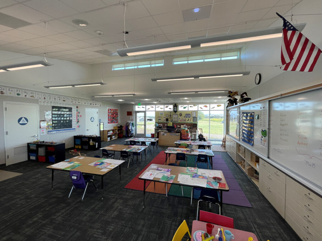 Well-organized kindergarten classroom at Old Adobe School with colorful tables, workspaces, and modern design elements.