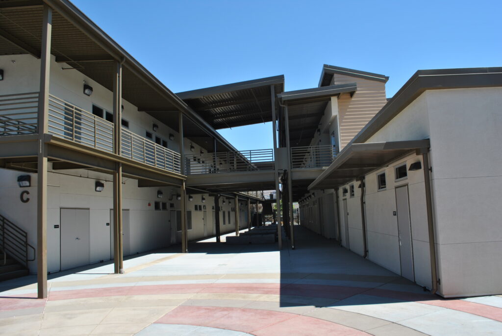 View of the courtyard and walkways at WC Overfelt Adult Education Center, featuring two-story modular buildings designed for educational use.