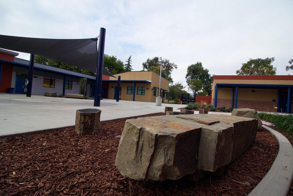 Exterior view of the Hart Middle School science building featuring stone landscaping and modern modular classroom designs.